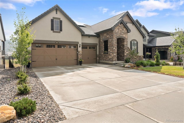 3147 S Quaker St, Morrison, CO 80465 - view of front facade featuring stone siding, stucco siding, concrete driveway, a tiled roof, and an attached garage