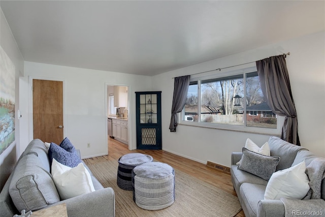 living room with light hardwood / wood-style floors and sink