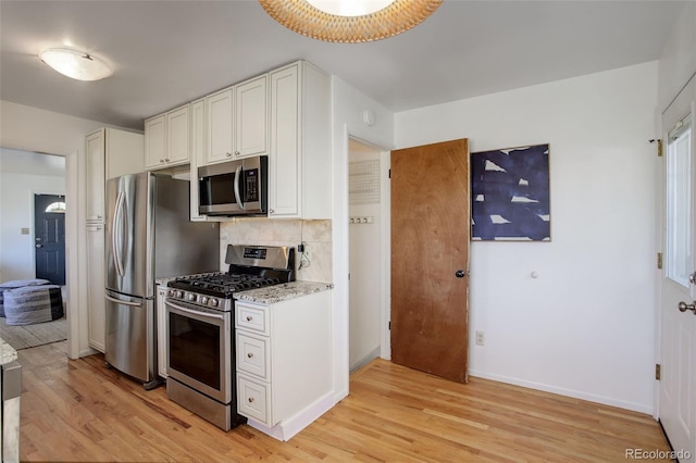 kitchen featuring white cabinets, decorative backsplash, light hardwood / wood-style floors, and appliances with stainless steel finishes