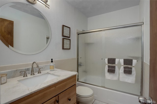 full bathroom with tile patterned floors, vanity, toilet, and shower / bath combination with glass door