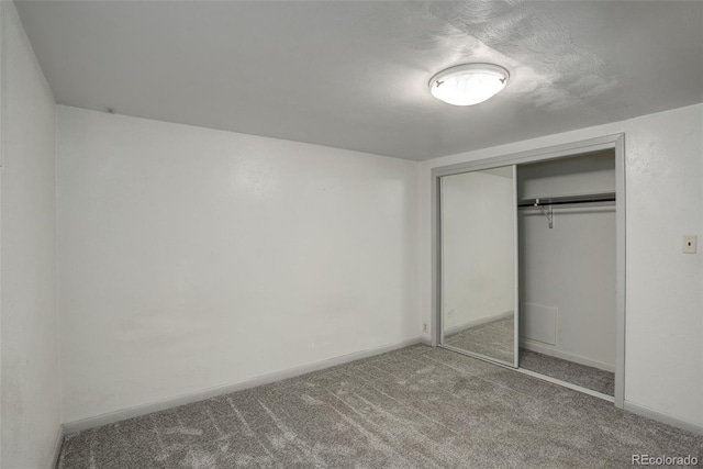 unfurnished bedroom featuring carpet floors and a closet