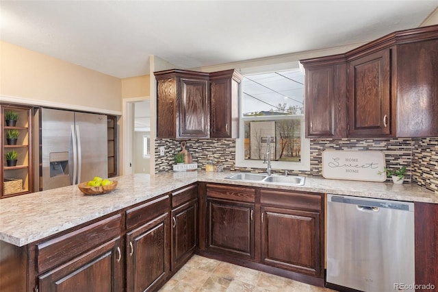 kitchen with light countertops, a sink, appliances with stainless steel finishes, a peninsula, and dark brown cabinets