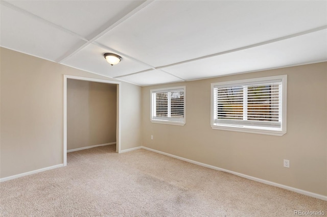 empty room featuring baseboards, lofted ceiling, and carpet flooring