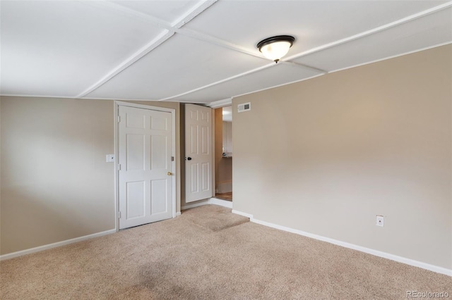 carpeted spare room featuring baseboards and visible vents