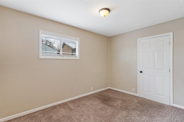 empty room with baseboards and carpet