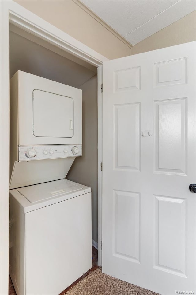 washroom featuring stacked washer / drying machine, laundry area, and carpet