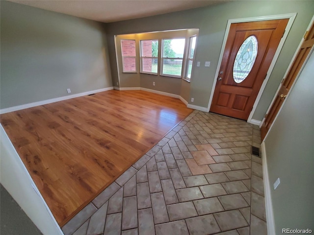 foyer entrance with light wood-style floors and baseboards