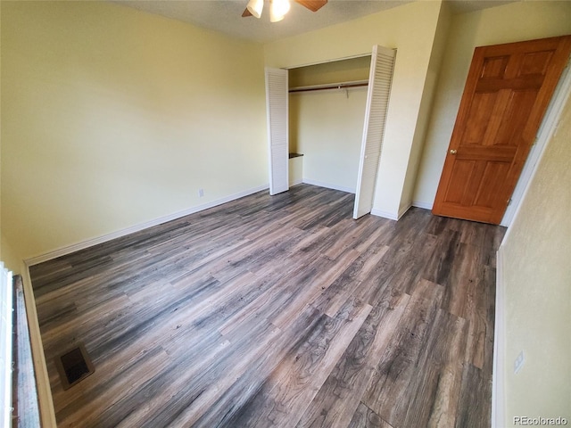 unfurnished bedroom with dark wood-style floors, a closet, and ceiling fan
