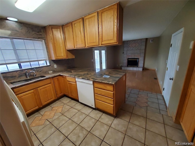 kitchen featuring white dishwasher, light tile patterned flooring, open floor plan, and a peninsula