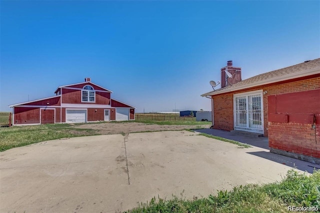 view of yard with a detached garage, an outdoor structure, and a barn