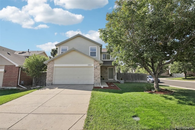 traditional-style house with brick siding, a front yard, concrete driveway, and fence