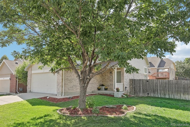 obstructed view of property with brick siding, concrete driveway, a front lawn, and fence