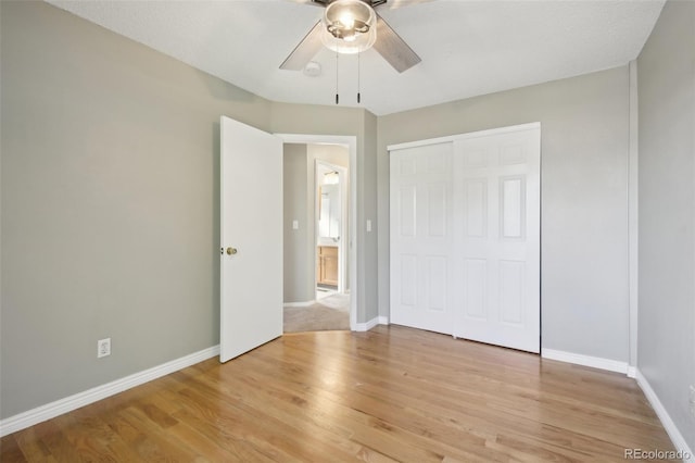 unfurnished bedroom with a closet, light wood finished floors, baseboards, and a ceiling fan
