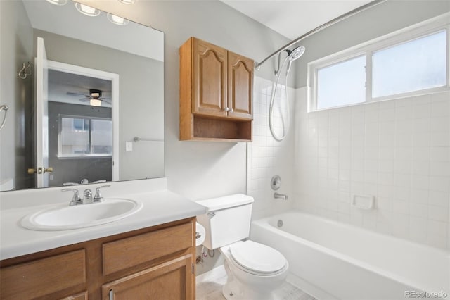 bathroom featuring toilet, a ceiling fan, vanity, and bathing tub / shower combination