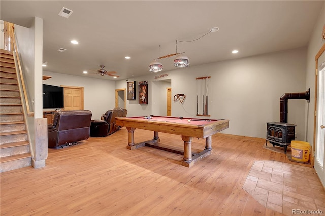 playroom with pool table, ceiling fan, light wood-type flooring, and a wood stove