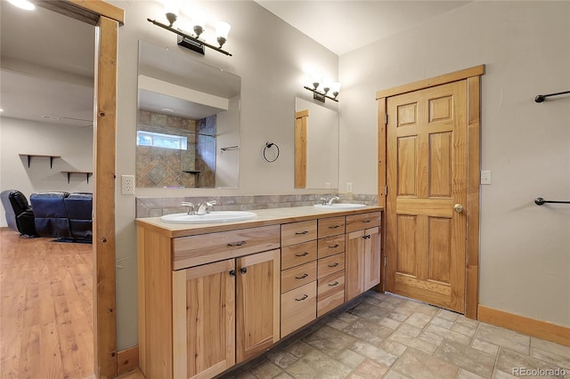 bathroom featuring a tile shower and vanity