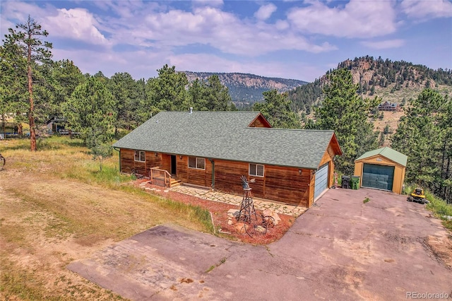 log home with an outdoor structure, a mountain view, and a garage