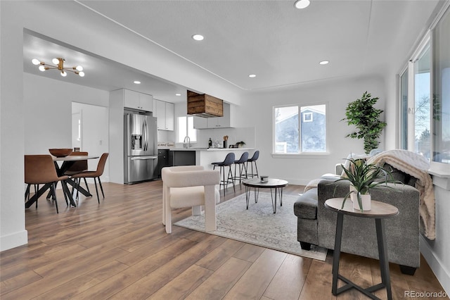 living area featuring recessed lighting, baseboards, and wood finished floors