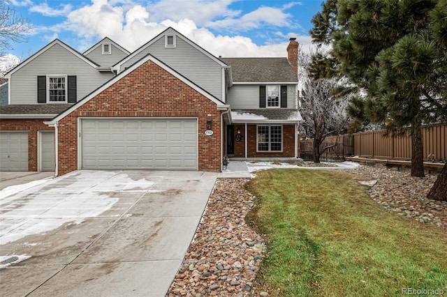 traditional-style house featuring brick siding, a chimney, a front yard, fence, and driveway