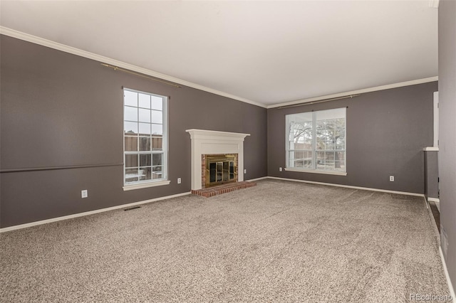 unfurnished living room with plenty of natural light, carpet, a fireplace, and crown molding