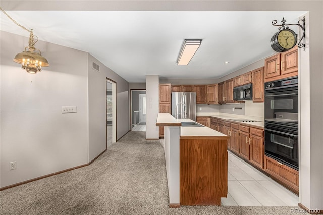 kitchen featuring visible vents, light countertops, light carpet, black appliances, and a kitchen island with sink