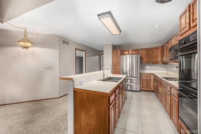 kitchen featuring black appliances, light countertops, brown cabinets, and a sink