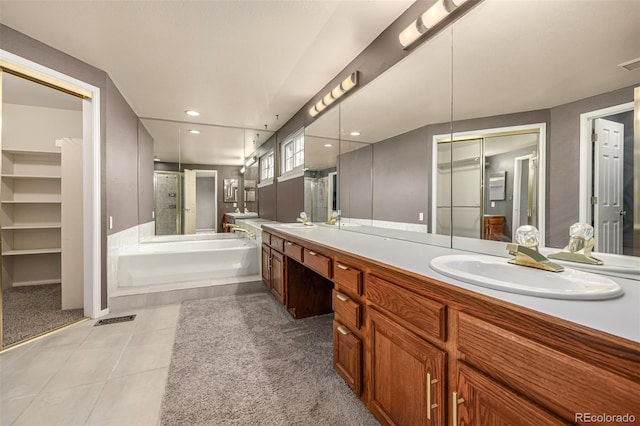 full bath featuring a sink, a garden tub, double vanity, and tile patterned floors