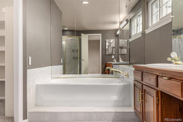 bathroom with vanity, a bath, and a stall shower