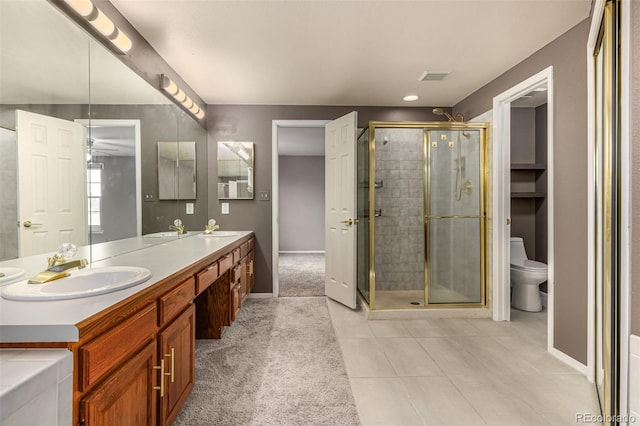 full bathroom featuring visible vents, a shower stall, toilet, double vanity, and a sink