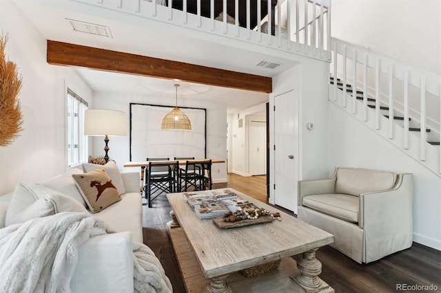 living room with dark wood-type flooring and beamed ceiling