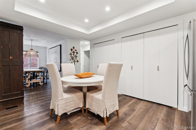 dining area featuring dark hardwood / wood-style floors and a tray ceiling