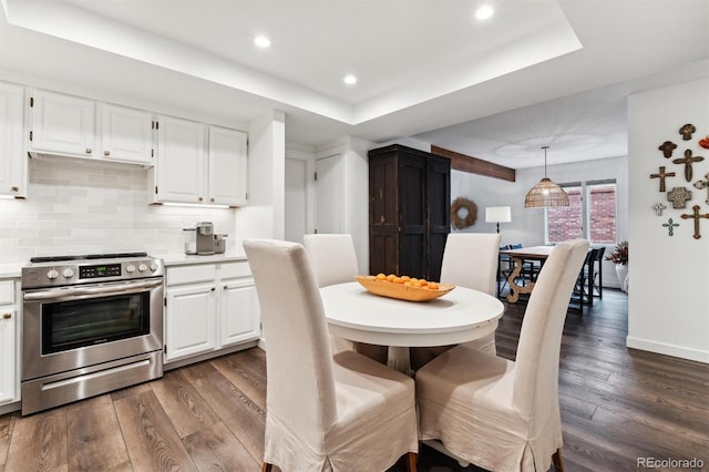 dining area featuring dark hardwood / wood-style flooring and a raised ceiling