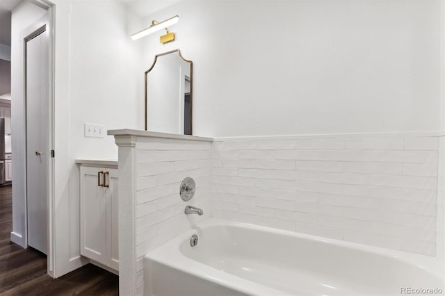 bathroom featuring a tub, wood-type flooring, and vanity