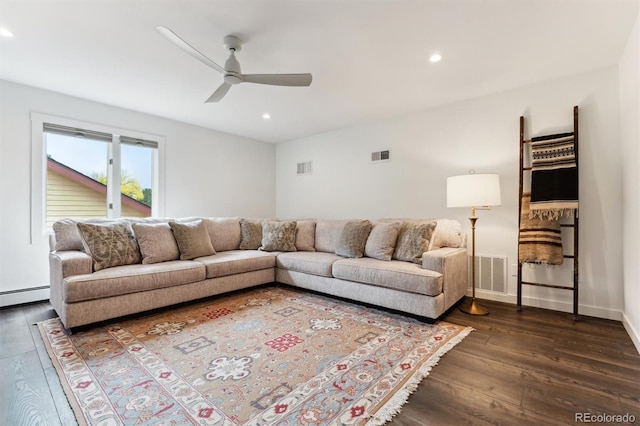 living room with dark hardwood / wood-style flooring, ceiling fan, and a baseboard heating unit