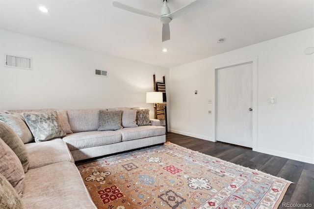 living room featuring dark wood-type flooring and ceiling fan