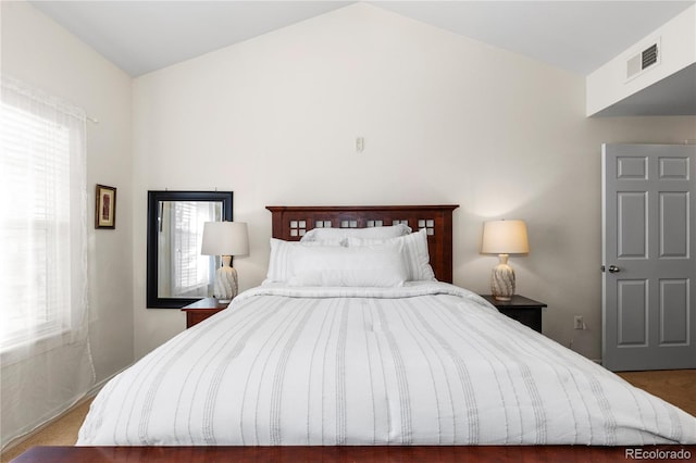 bedroom featuring vaulted ceiling and visible vents