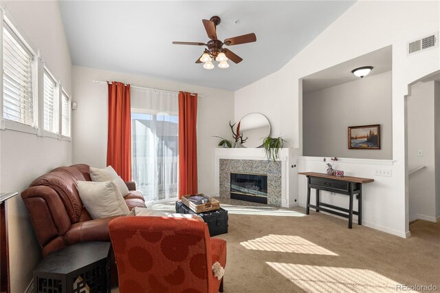 living area featuring vaulted ceiling, a premium fireplace, carpet flooring, and visible vents