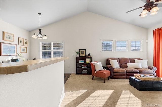 carpeted living room featuring vaulted ceiling and ceiling fan with notable chandelier