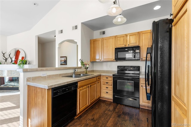 kitchen with vaulted ceiling, visible vents, a sink, and black appliances