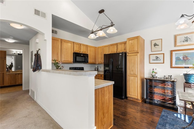 kitchen featuring a peninsula, black appliances, and visible vents