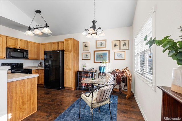 kitchen featuring hanging light fixtures, black appliances, light countertops, and dark wood-type flooring