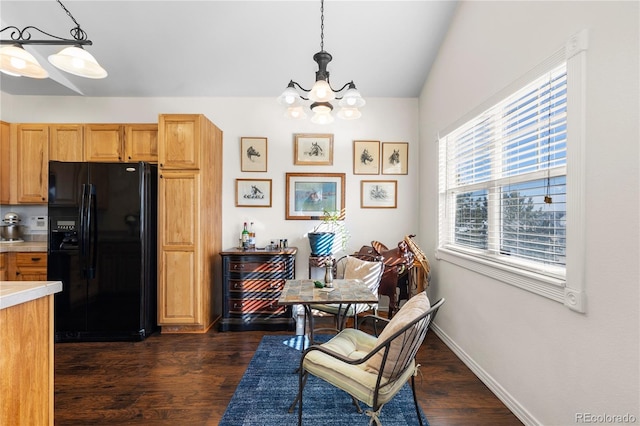 kitchen featuring a notable chandelier, dark wood-style flooring, light countertops, black refrigerator with ice dispenser, and pendant lighting