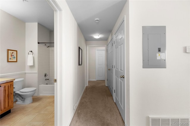 hallway featuring light tile patterned floors, visible vents, light carpet, electric panel, and baseboards