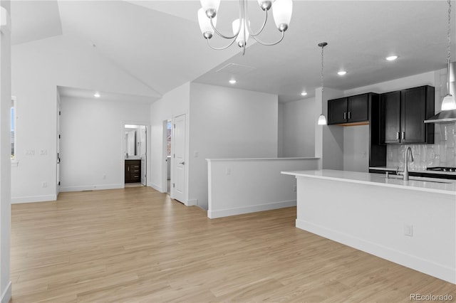 6129 Zebulon Pl, Timnath, CO 80547 - kitchen featuring a sink, wall chimney range hood, light countertops, decorative backsplash, and light wood-style flooring