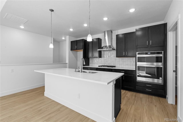 6129 Zebulon Pl, Timnath, CO 80547 - kitchen with wall chimney exhaust hood, a sink, dark cabinets, gas stovetop, and double oven