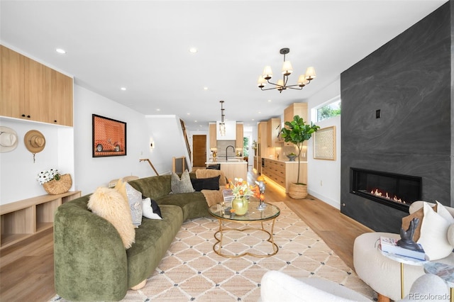 2926 S Cherokee St, Englewood, CO 80110 - living room with light wood-type flooring, recessed lighting, a fireplace, and a chandelier