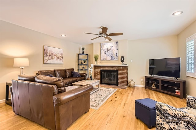 living area with a ceiling fan, wood finished floors, recessed lighting, a fireplace, and baseboards