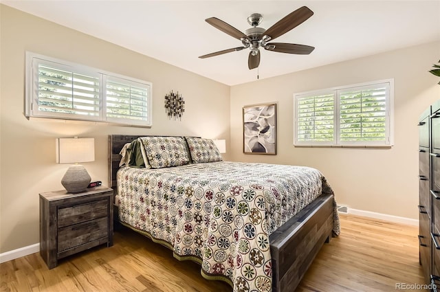 bedroom featuring light wood-style flooring, multiple windows, and baseboards