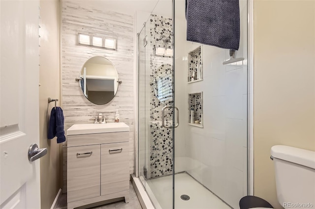 bathroom with a stall shower, vanity, and toilet