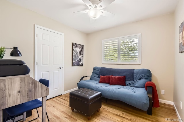 living area with ceiling fan, light wood finished floors, and baseboards